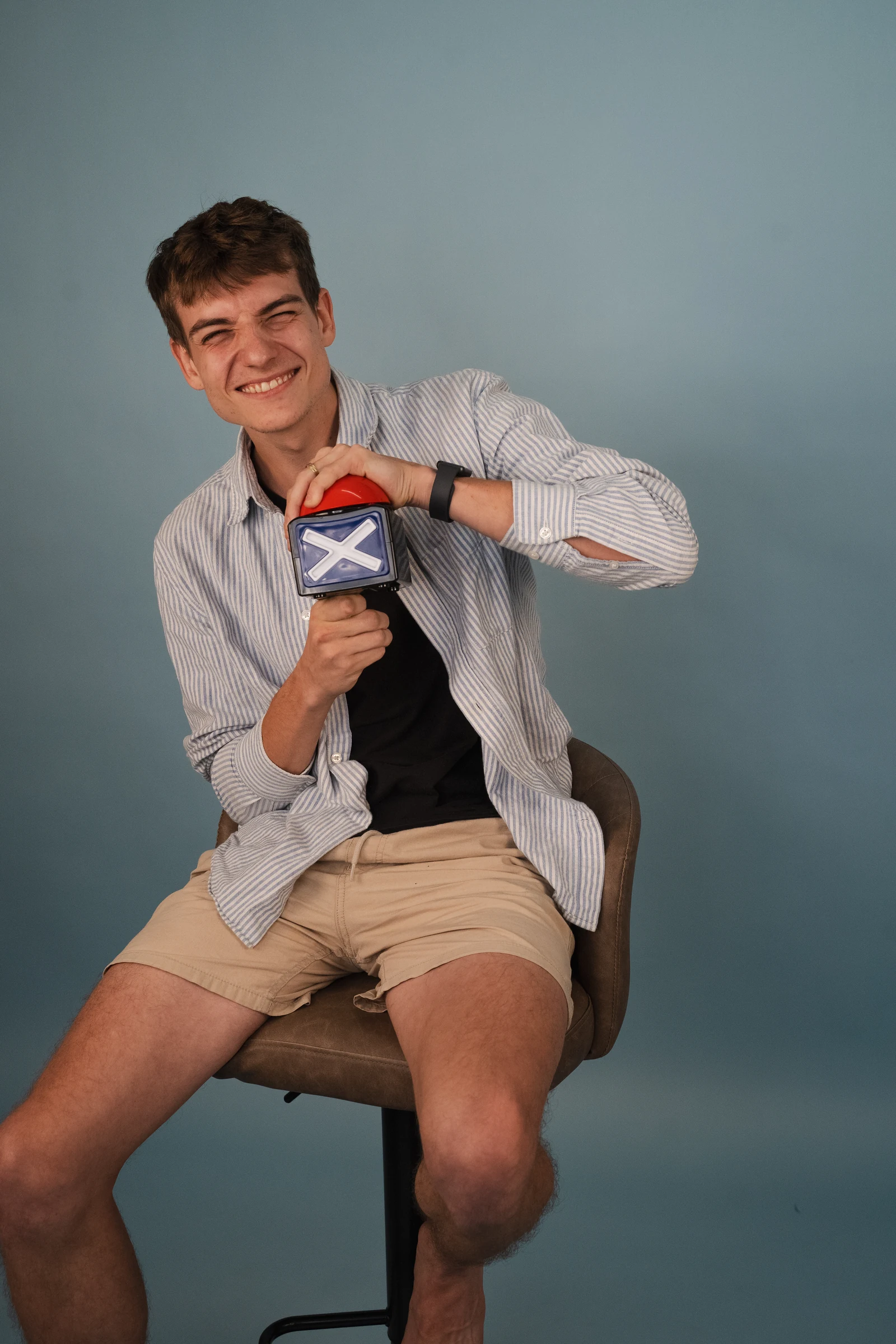 Ondra smiling with a game-show buzzer during a studio photoshoot